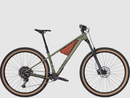Matte Olive Trek Roscoe 7 with tan-walled tires and brown frame bag on a white background. 