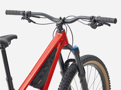 Close up view of handlebars of red Trek Roscoe mountain bike with black components  with white background. 