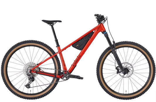 Red Trek Roscoe  mountain bike on a white background with black frame bag and black components.