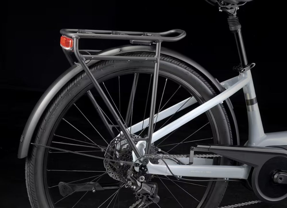 Trek Verve Plus bicycle with a rear light on a black rear rack with a background.
