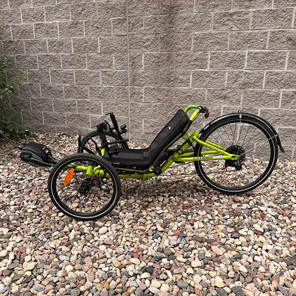 Non-drive side view of the Catrike Used 5.5.9 eCat Eon Green Recumbent Trike in an outdoor setting.