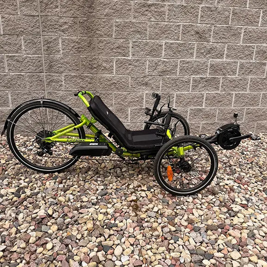 Side view of the Catrike Used 5.5.9 eCat Eon Green Recumbent Trike in an outdoor setting.