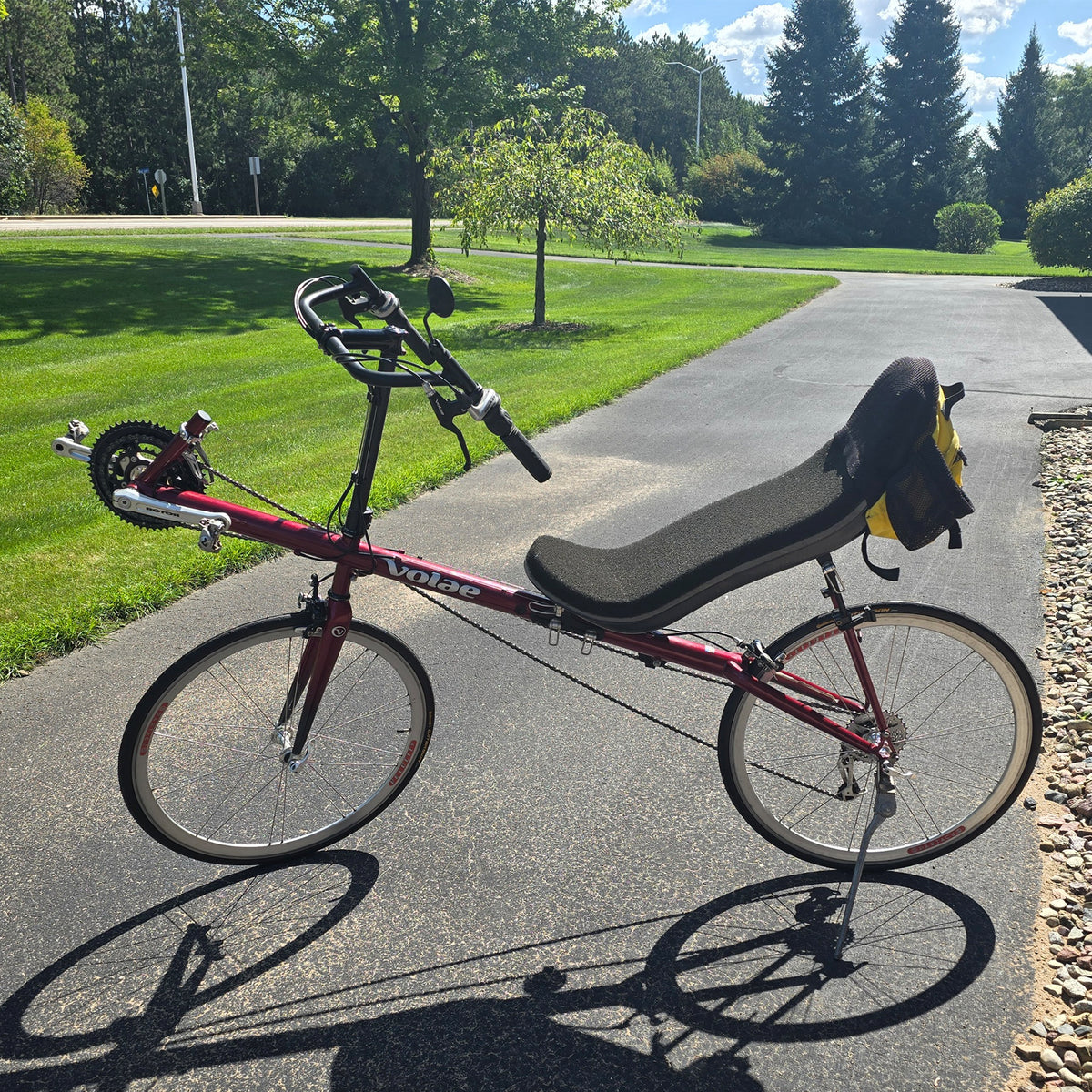 Non-drive side view of the Volae Used Club Dual 650c Red Large Recumbent Bike in an outdoor setting.