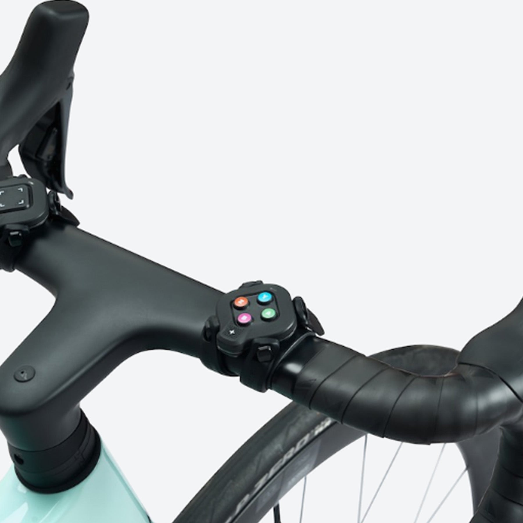 Closeup view of the Zwift Click module on a road bike handlebar for a Wahoo indoor cycling trainer against a white background.