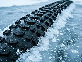 Image of a bike tire tread poking up through solid ice.