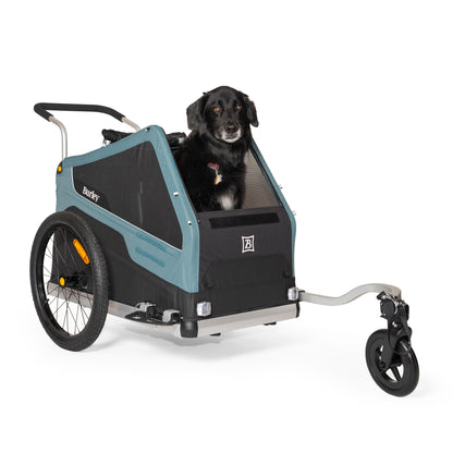 Front quarter view of the Burley Bark Ranger Pet Trailer, shown with a black dog sitting inside, on a white background.