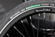 Close up view of Schwalbe Green Compound Road tire on black rim with white TerraTrike logo on rim, presta valve