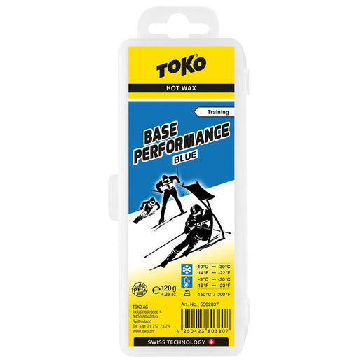 Package of Toko Performance Blue base wax.  Package is mostly yellow, with image of 3 black and white skiers, blue sky and white snow.  Black lettering on front of package.