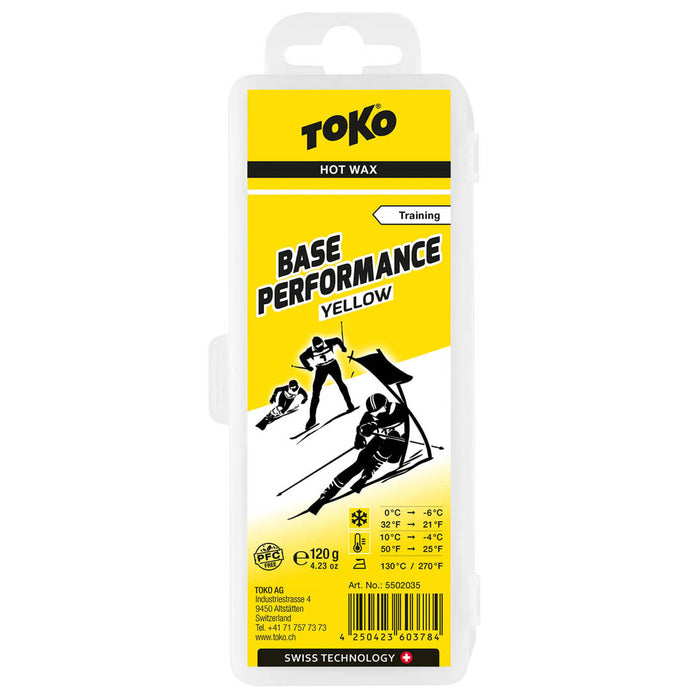 Front view of packaging for Toko Performance Yellow Base wax. Package is mostly yellow with black lettering and 3 black and white skiers