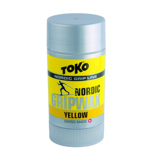 A stick of Toko Nordic Grip Wax in yellow, with branding and product information printed on the label.