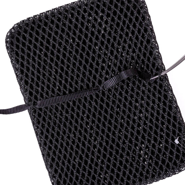 Studio image of nylon strap being pulled with long nose needle nose pliers through the mesh of a black Ventisit pad