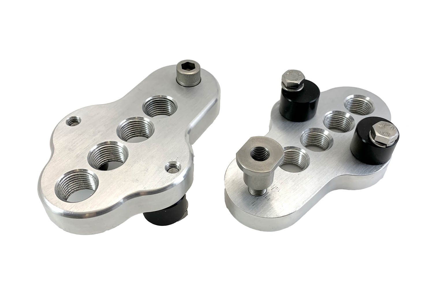 A top and bottom view of a pair of silver CJ Ackley Machine Company Wide Crank Arm Shorteners.