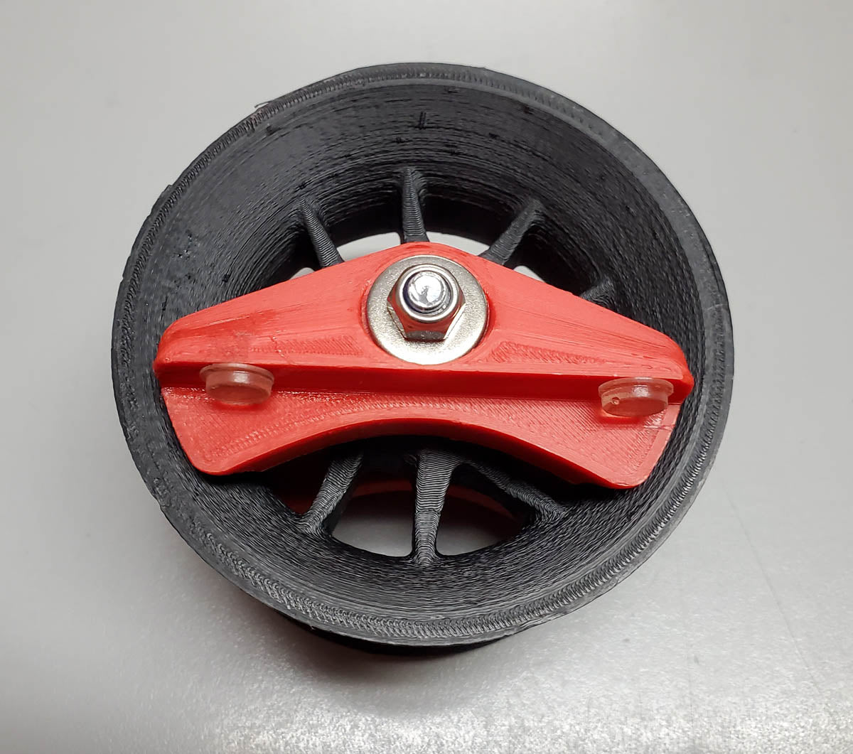 Studio image of black and red plastic Hase wheel workstand adapter.