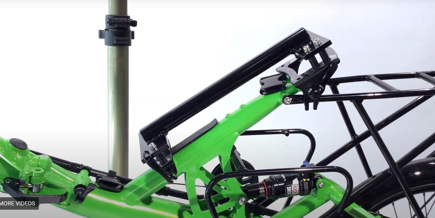 View of the HP Velotechnik Scorpion Assembly Mount Workstand Bracket attached to a green recumbent bike against a white background.