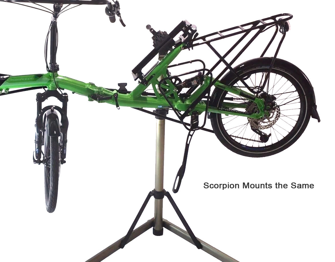 View of the HP Velotechnik Scorpion Assembly Mount Workstand Bracket attached to a green recumbent bike on a workstand against a white background.