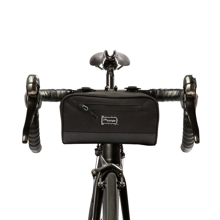 Front side of the Black ripstop domino handlebar bag mounted onto the handlebars and head tube of a bike.
