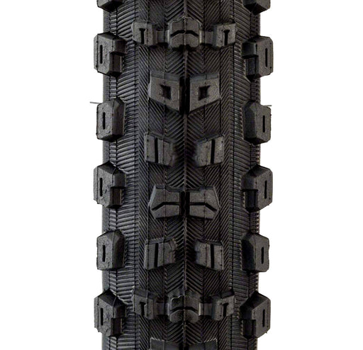 Studio image of the close up of the tread on a black Maxxis Aggressor tire.  