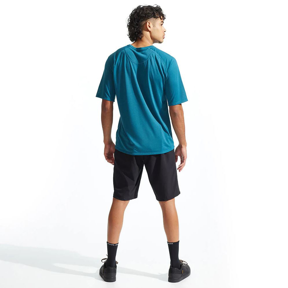 Back view on a model in a teal tee with a Pearl Izumi Mens Canyon Short with Liner in black against a white background.