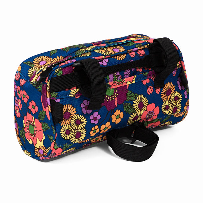 Back of the "Meadow Domino Handlebar Bag" featuring two adjustable black straps to help mount to bike handlebars. One adjustable strap at the bottom to adjust and tighten around the head tube.
