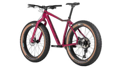 Left profile view of purple Salsa Mukluk fat bike with black accents, black components, and tan sidewall tires on a white background. 