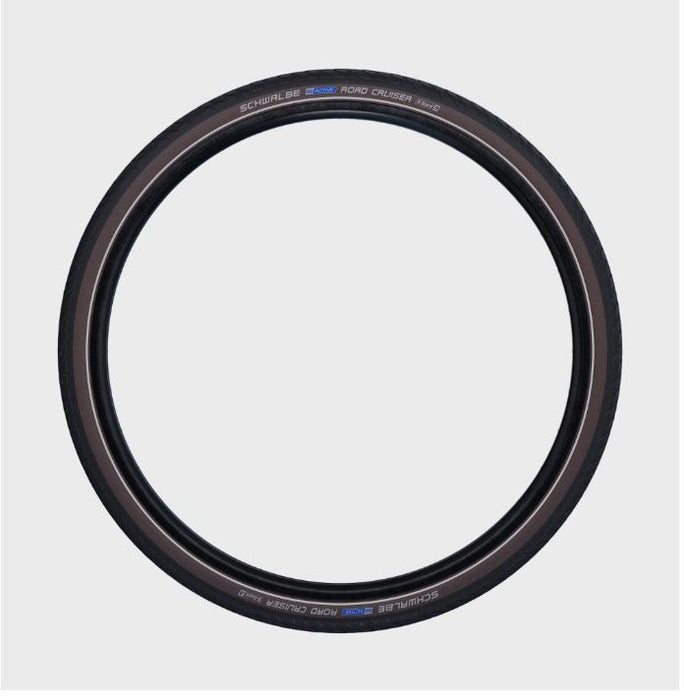 Studio image of a black Schwalbe Road Cruiser tire showing the thin reflective line along the tire's sidewall