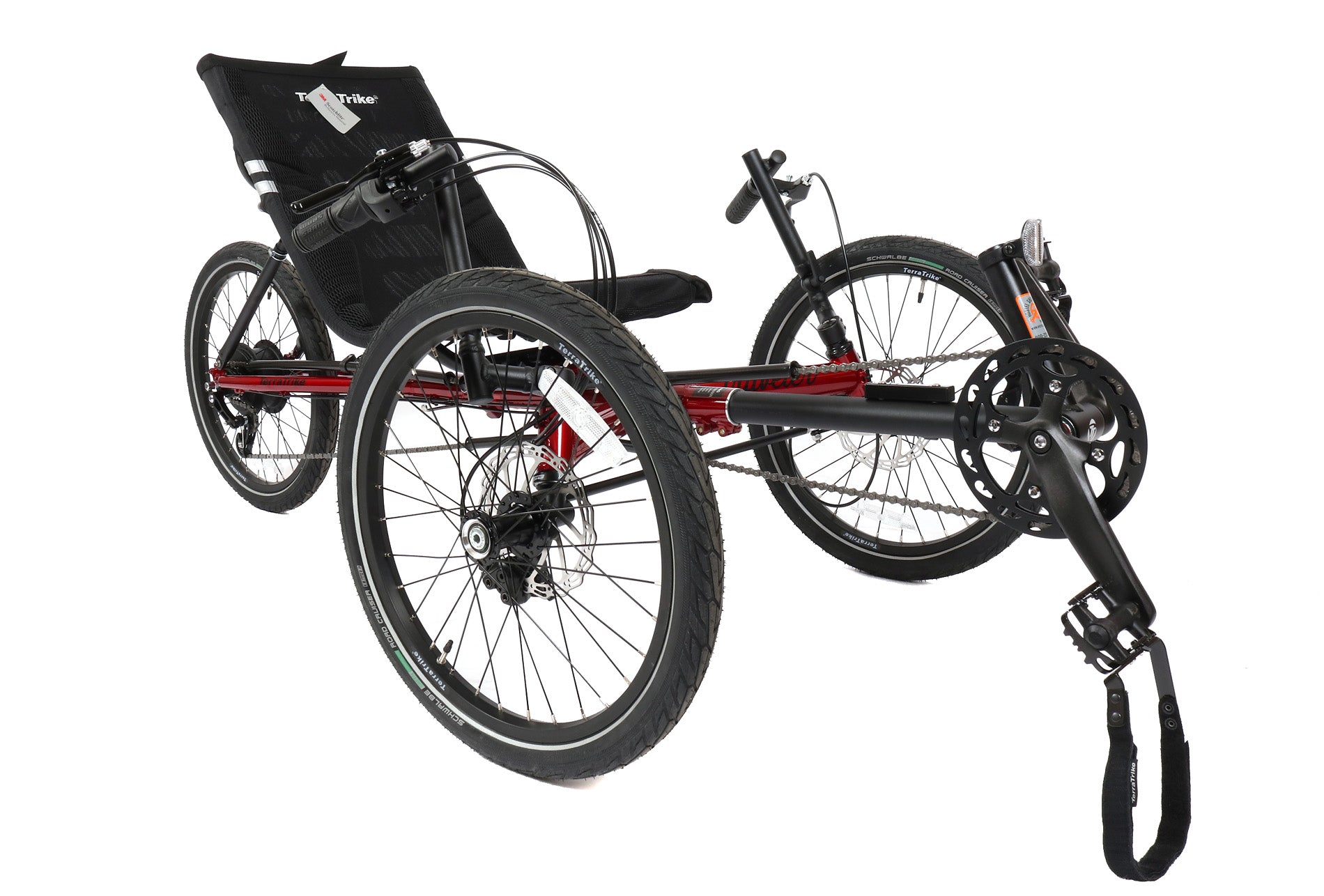 Angled view of a red and black TerraTrike Traveler recumbent trike with a black seat and folding handlebars, equipped with a chain drive and mechanical disc brakes.