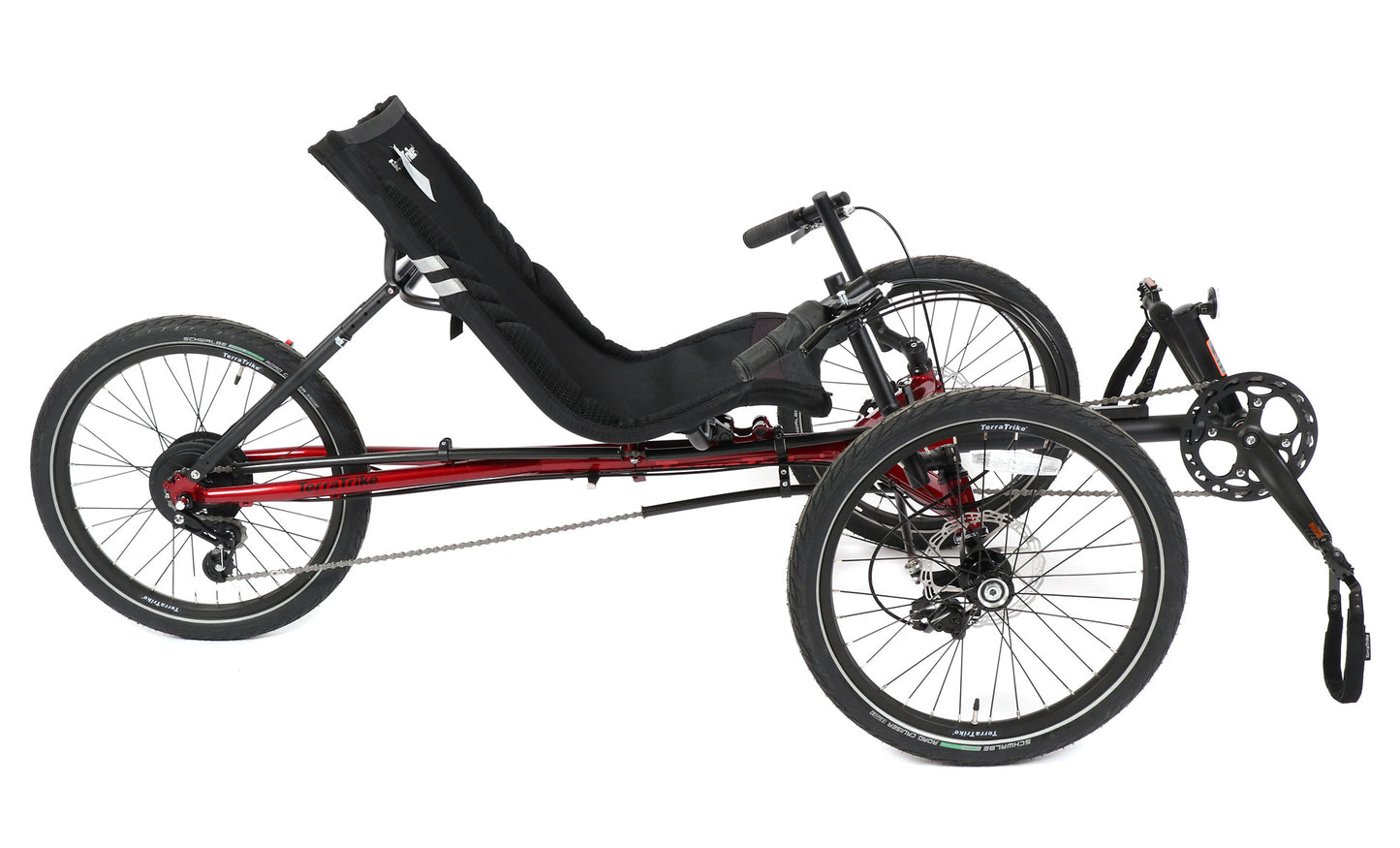 Side view of a red and black TerraTrike Traveler recumbent trike with a black seat and folding handlebars, equipped with a chain drive and mechanical disc brakes.